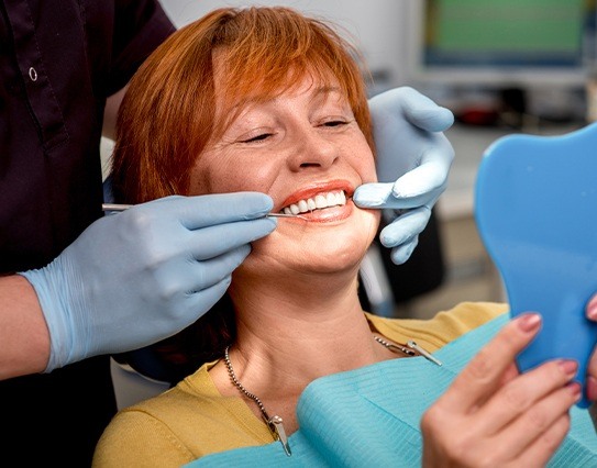 Woman at preventive dentistry visit to avoid the need for emergency dental care