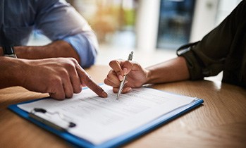 Two people reviewing forms on clipboard