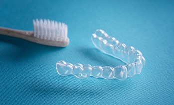 Two clear aligners sitting on a reflective surface