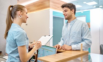 Patient talking to dental team member at front desk