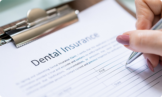 Filling out a dental insurance form on a clipboard