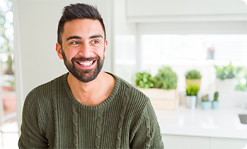 Man in green shirt smiling in kitchen