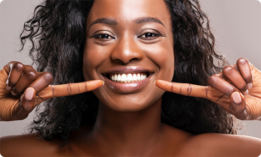 Woman pointing to her teeth and smiling