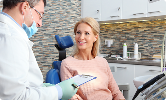 Female patient in pink shirt smiling at dentist