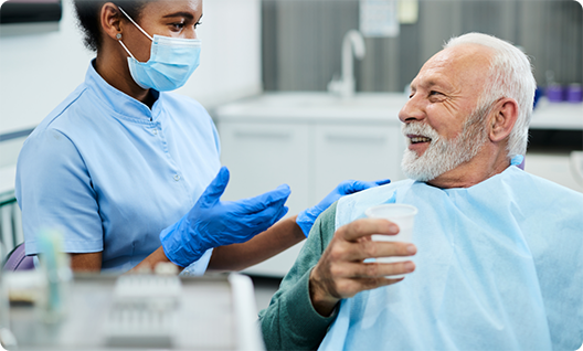 Senior man looking up and talking to dentist