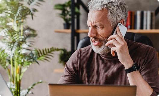 Man in brown shirt talking on phone