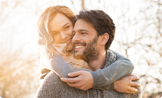 Man giving woman piggyback ride outside