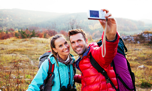 Man and woman taking photo while hiking