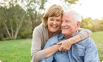 Woman hugging man from behind and smiling