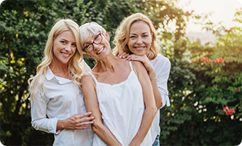 Three women standing outside and smiling