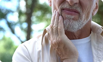 Close up of senior man rubbing jaw