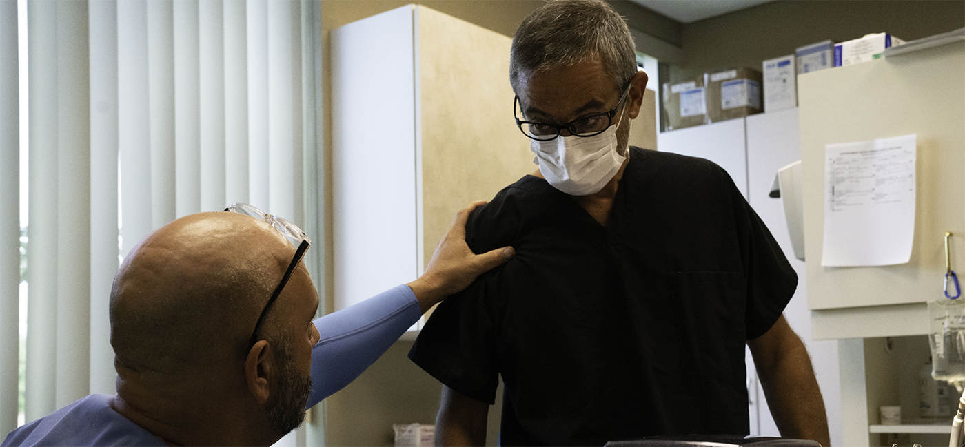 Patient putting hand on dentists shoulder