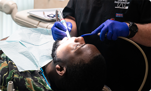 Man leaning back in chair being treated by dentist