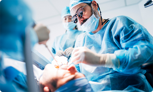 Dentist with mask performing dental implant placement