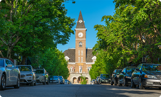 Clock tower with cars parked in front of it