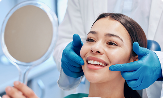 Female patient checking smile in handheld mirror