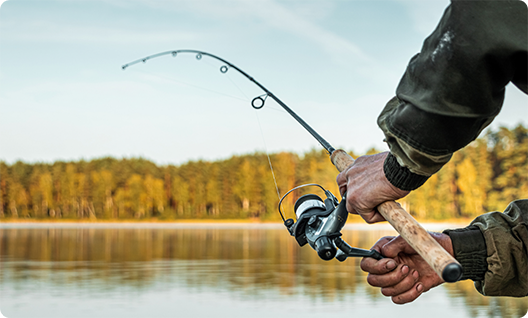 Close up of man using fishing pole at a lake