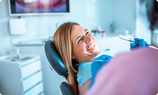 Blonde woman laughing in dental chair