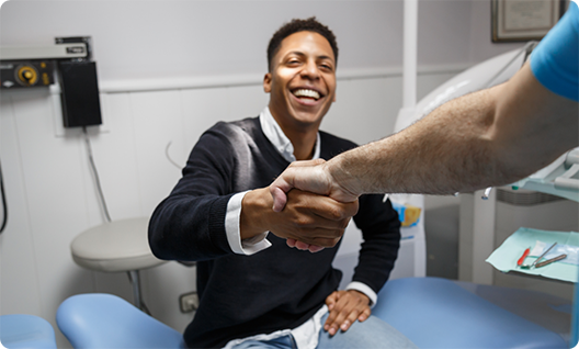 Male dental patient shaking dentists hand