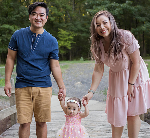 Dr Le and wife holding daughters hands and walking her along