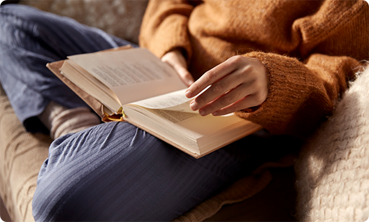 Person sitting on a couch reading a book