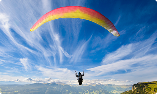 Person parachuting over some mountains